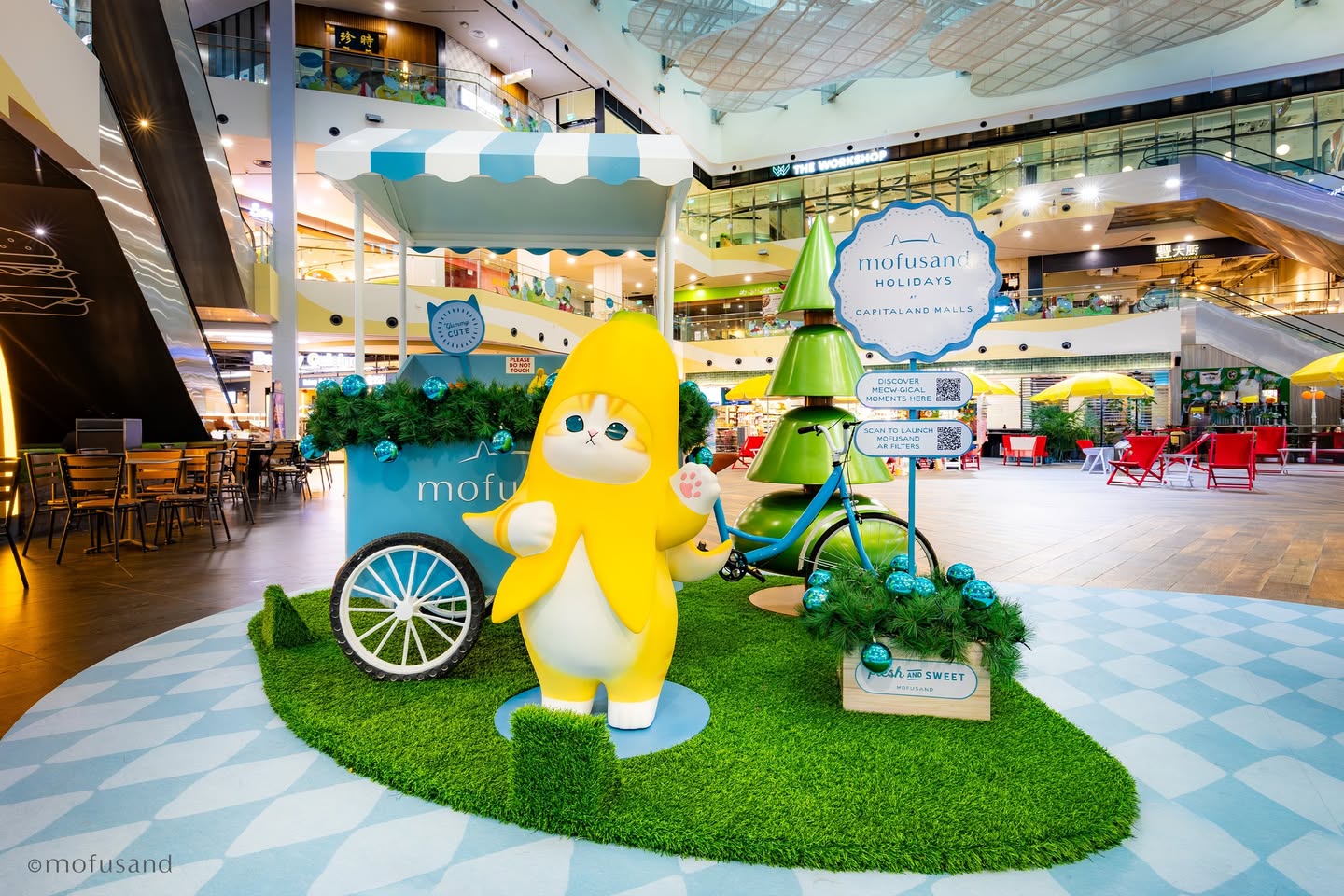 People interacting with Mofusand festive displays at a mall