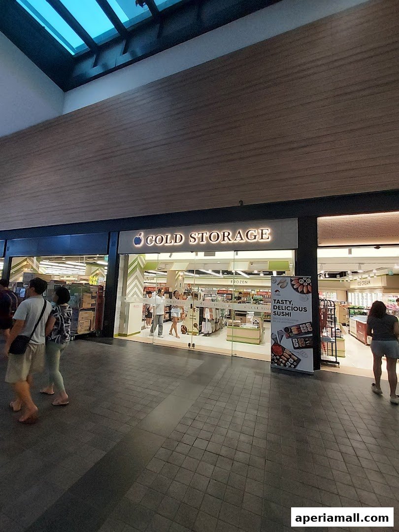The entrance of a Cold Storage supermarket with shoppers entering and exiting.