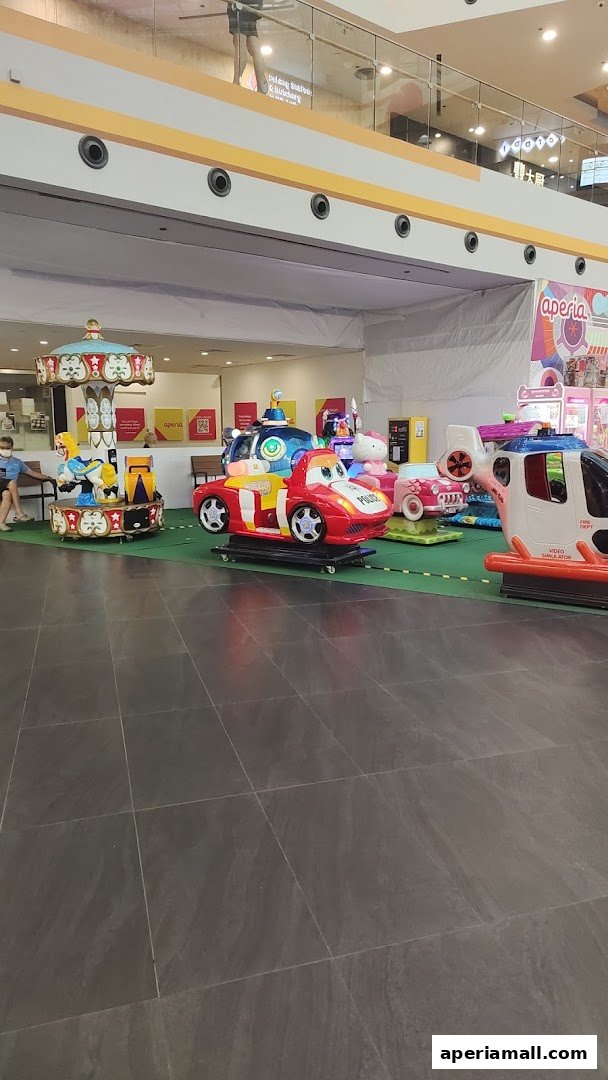 A row of colorful children's amusement rides in a shopping mall.
