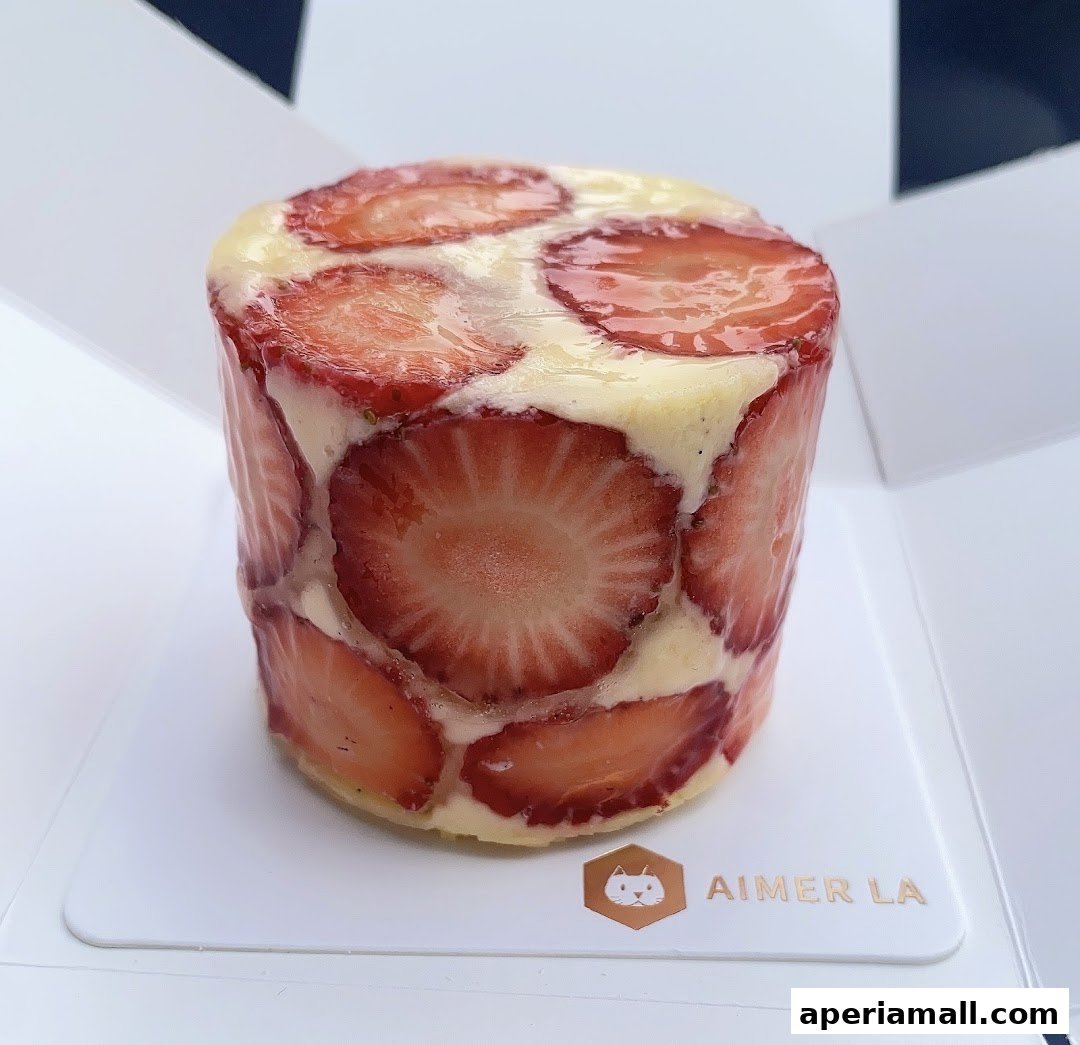 A close-up of a cylindrical cake decorated with fresh strawberry slices.