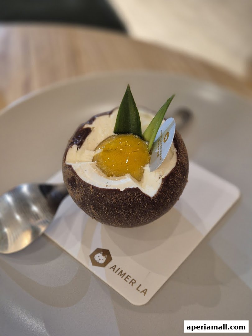 A beautifully crafted dessert with chocolate, cream, and fruit, served on a plate with a spoon.