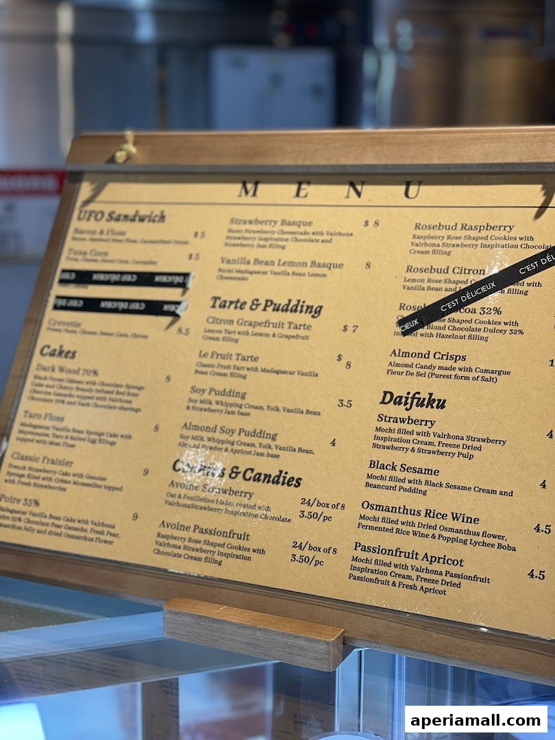 A close-up view of a pastry shop's menu board displaying various cakes and desserts.