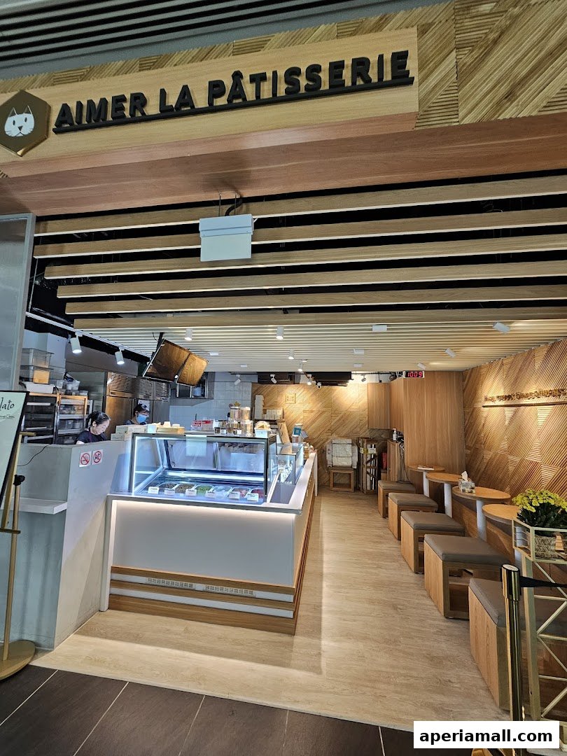 Interior view of Aimer La Patisserie, showcasing a gelato display and seating area.