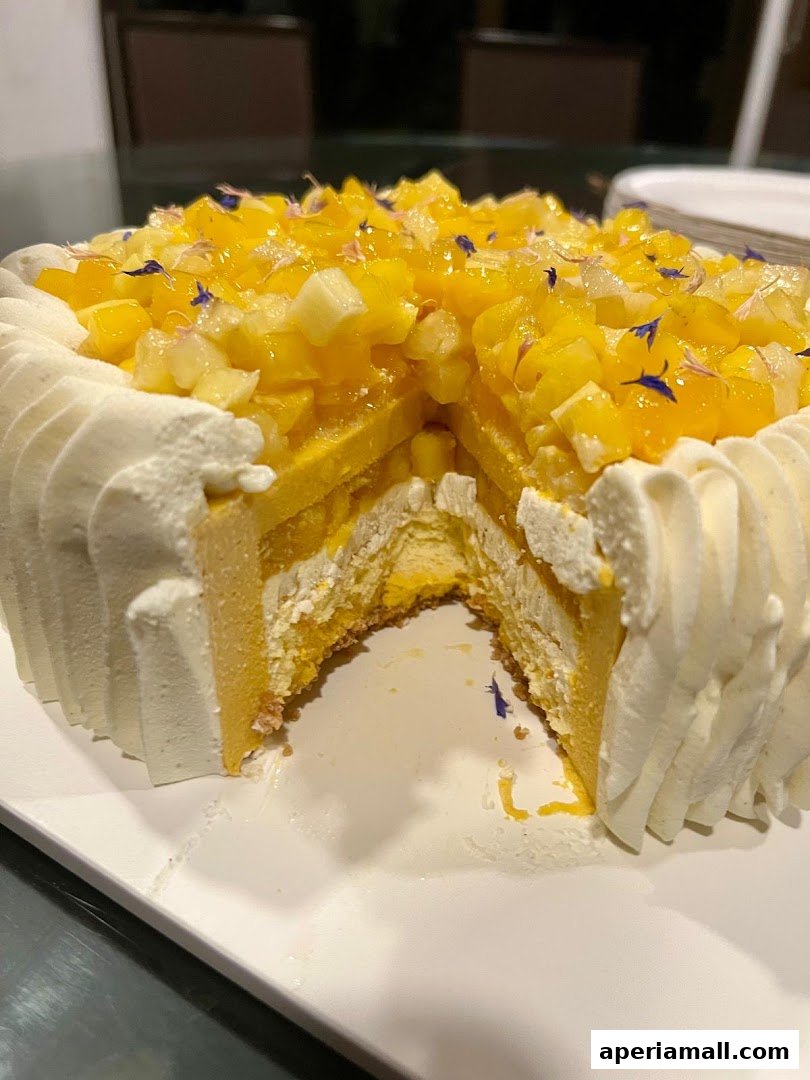 A slice of a beautifully decorated cake with layers of sponge, cream, and fresh fruit.