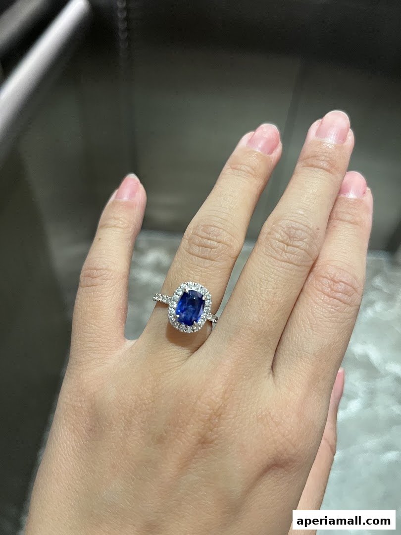A hand wearing a beautiful sapphire and diamond engagement ring.
