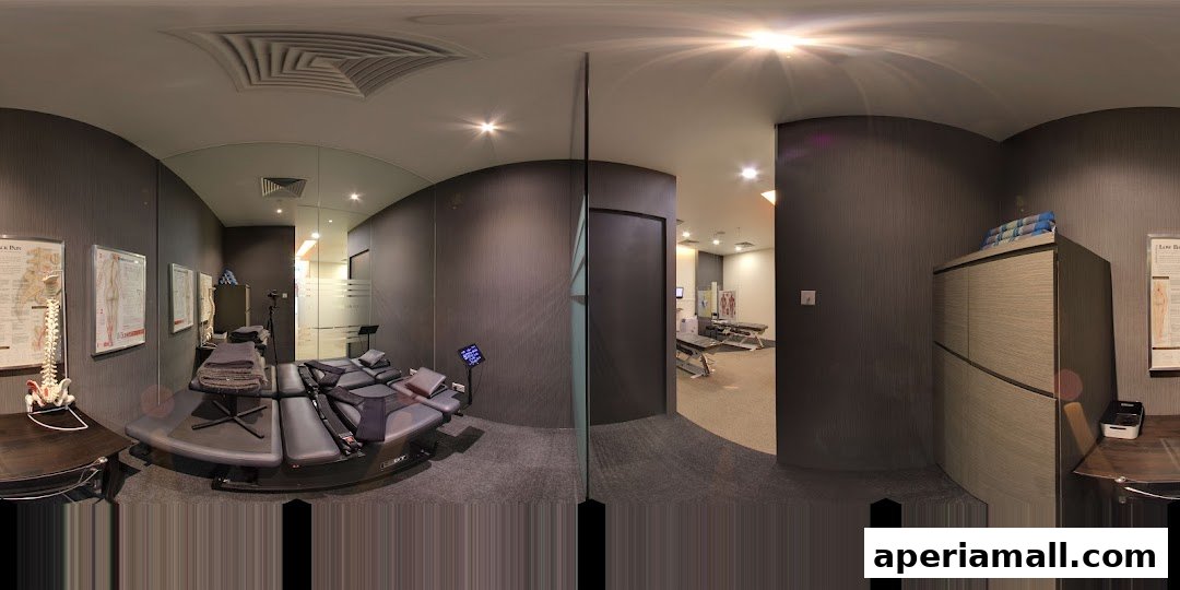 Interior view of a chiropractic clinic with treatment tables and anatomical charts.