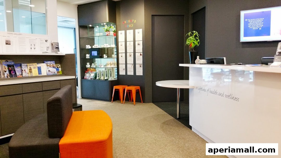 Interior of a chiropractic clinic with a reception desk, seating area, and display shelves.
