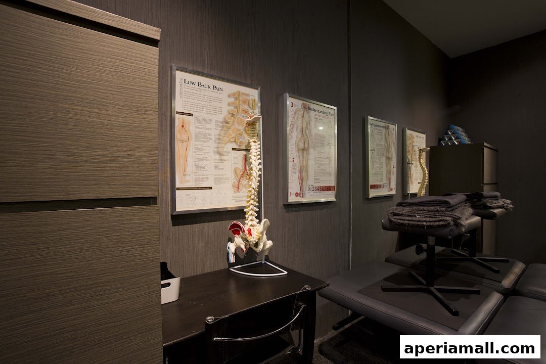 Interior of a chiropractic clinic with anatomical charts and treatment tables.