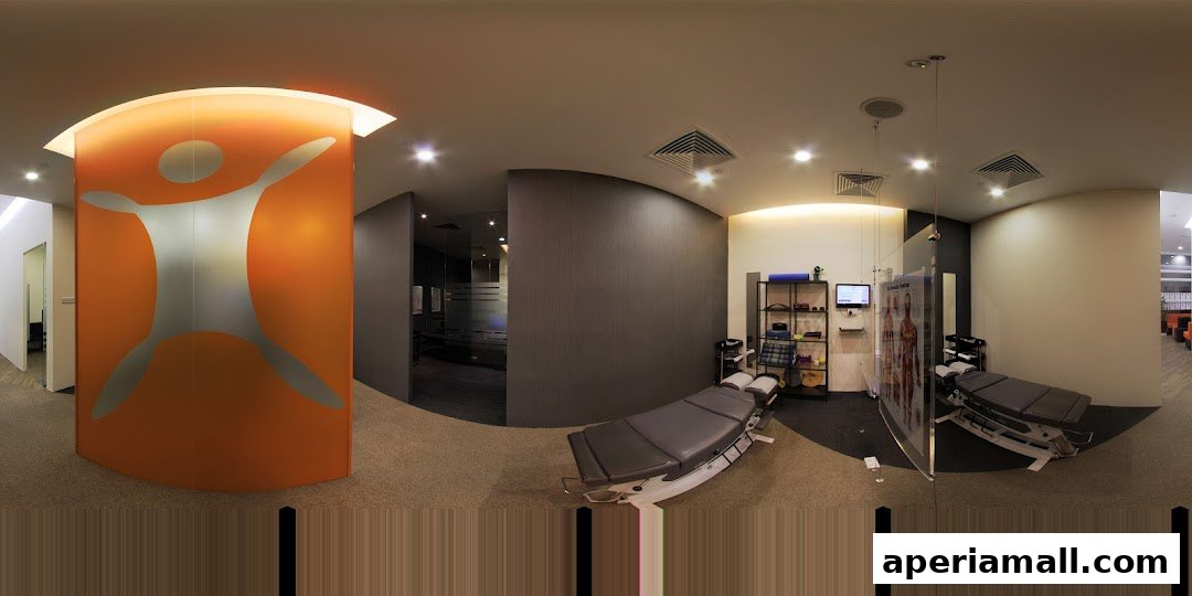 Interior view of a modern chiropractic clinic with treatment tables and anatomical charts.