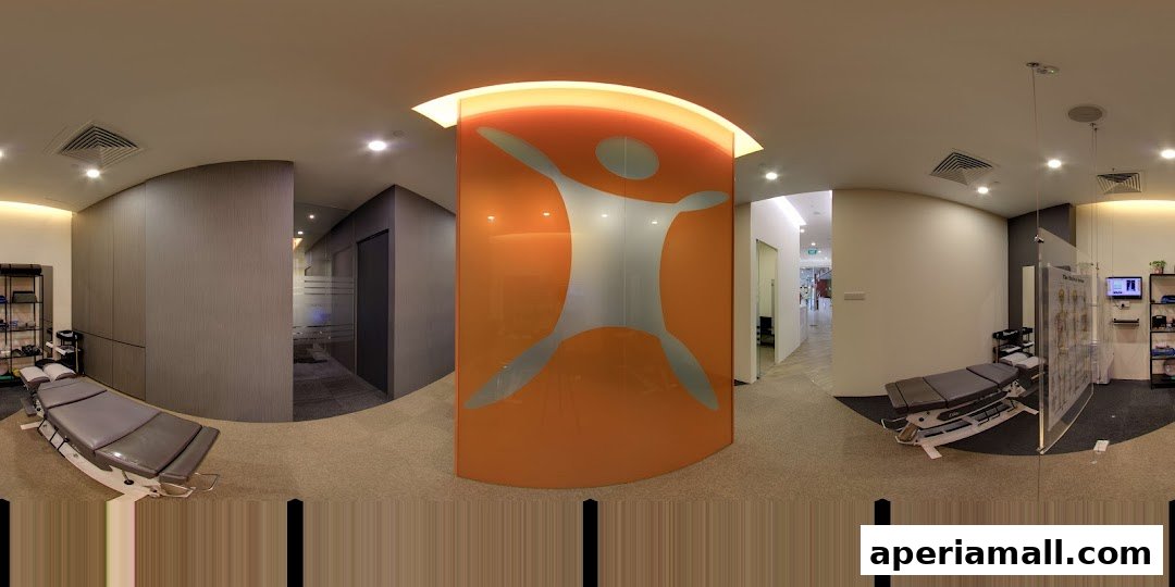 Interior view of a modern chiropractic clinic with treatment tables and anatomical charts.