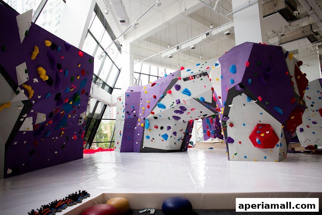 Interior view of a modern bouldering gym with colorful climbing walls and mats.