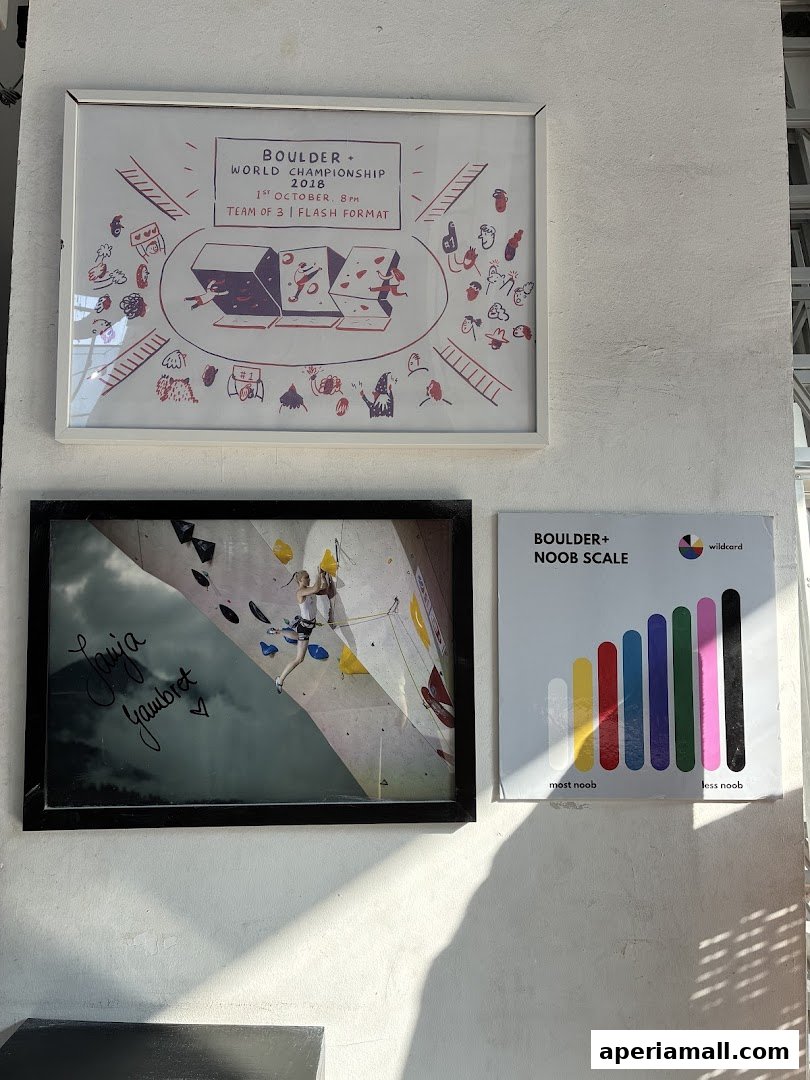 Framed posters related to bouldering, including a championship announcement and a climber.