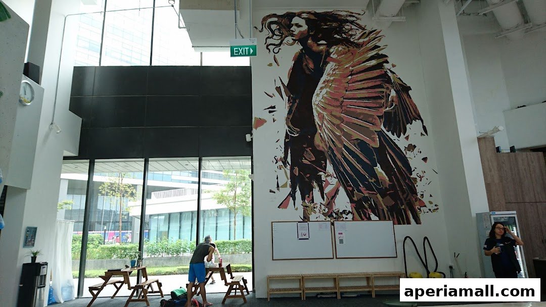 Interior of a modern space with a large mural, seating area, and staff.