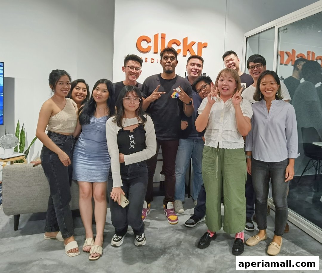 A group of smiling people posing for a photo in front of the Clickr Media Pte. Ltd. logo.