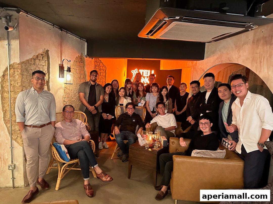 A group of people posing for a photo in a stylish lounge area with neon lighting.