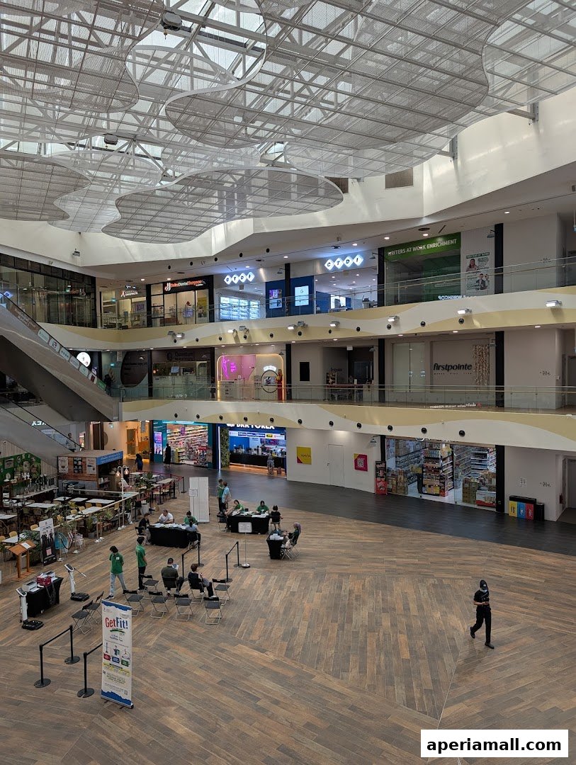 A wide view of a modern shopping mall interior with multiple levels and shops.