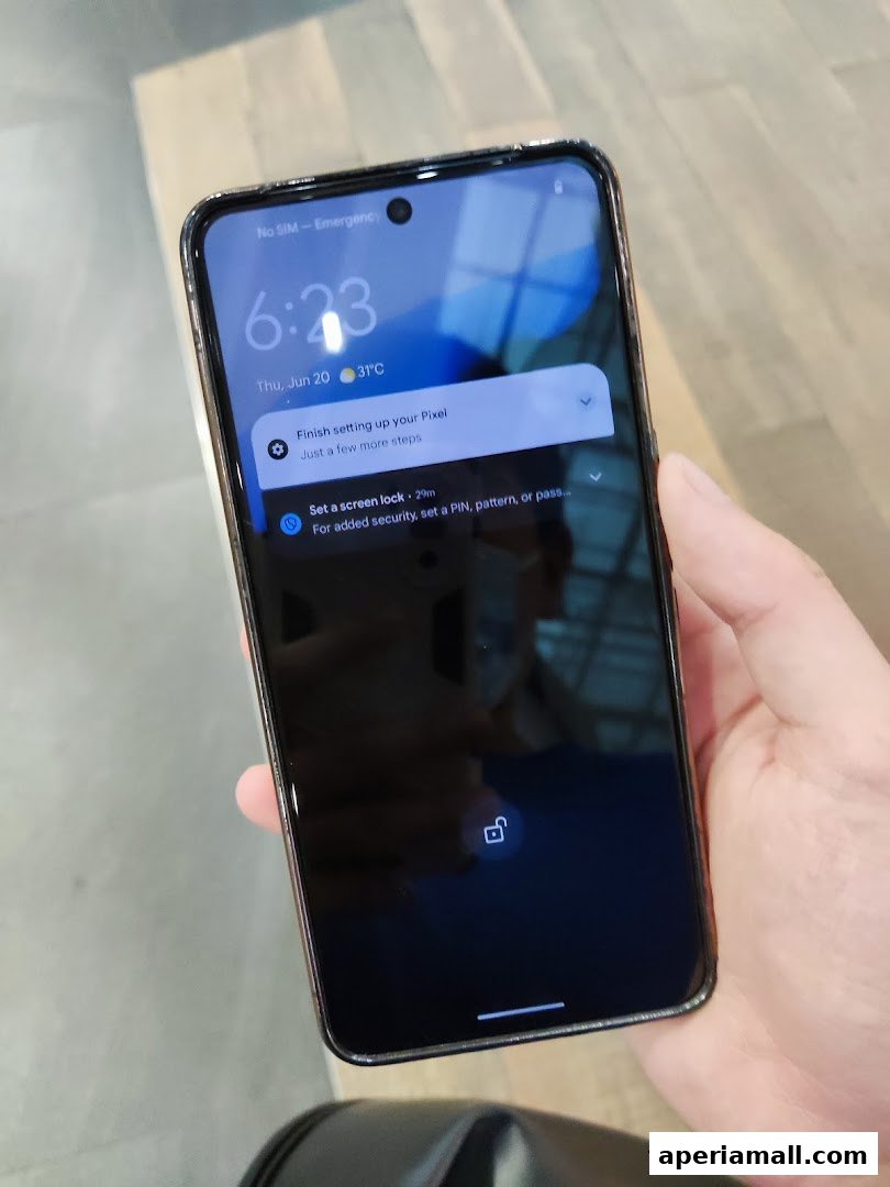 A hand holds a smartphone displaying its lock screen with time, date, and setup prompts.