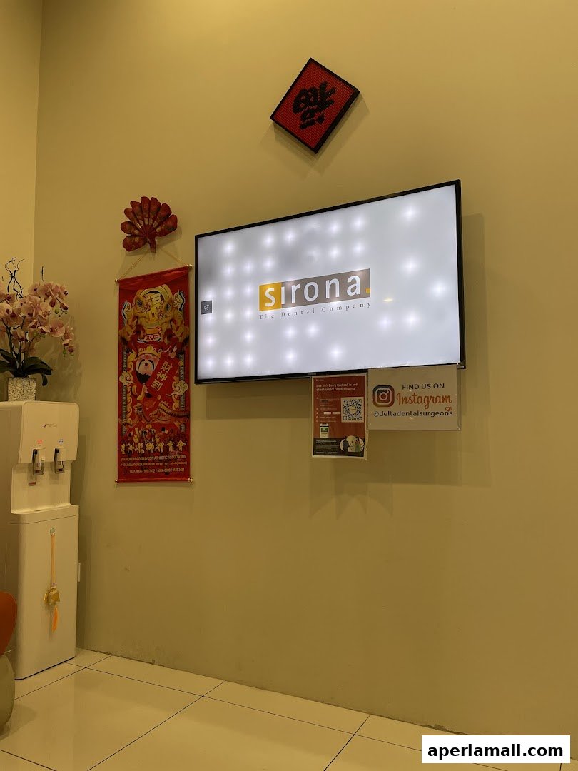 Interior shot of a dental clinic waiting area with a TV, water dispenser, and decorations.