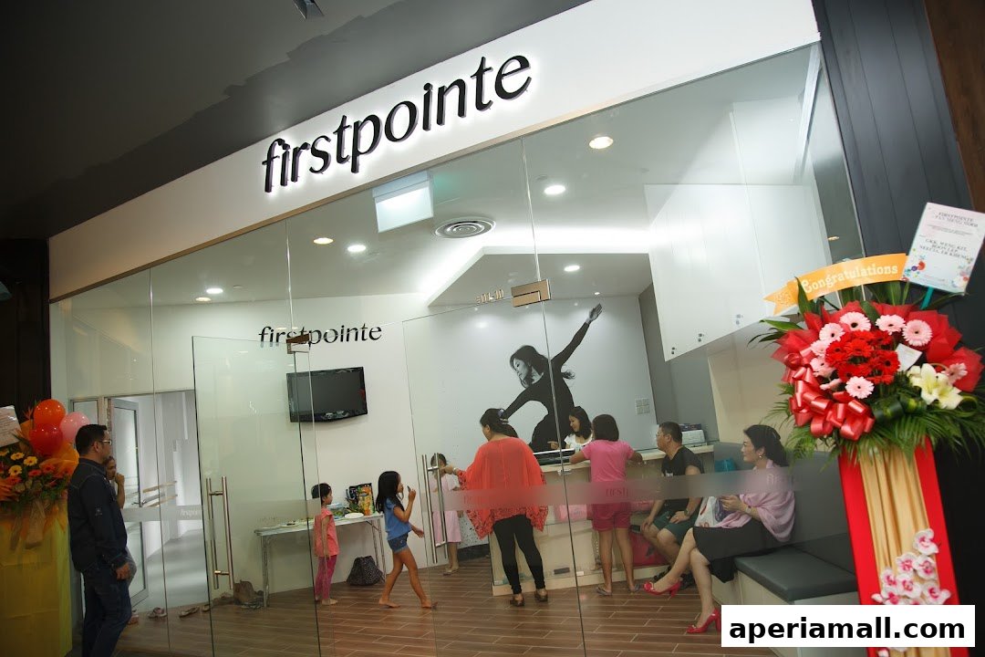 The entrance of a dance school with people inside and a congratulatory flower arrangement.