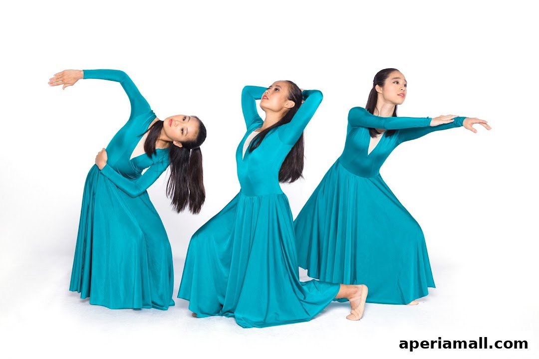Three young dancers in teal dresses striking graceful poses against a white background.