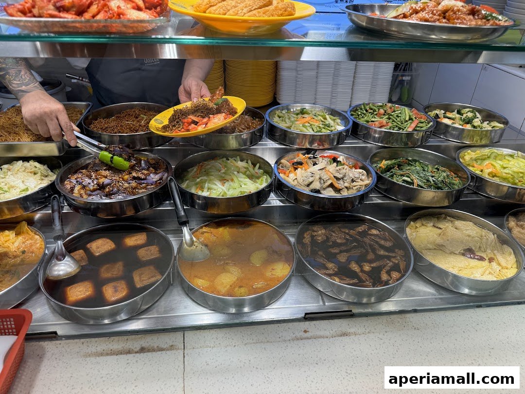 A display of various cooked dishes in metal trays, ready for serving.