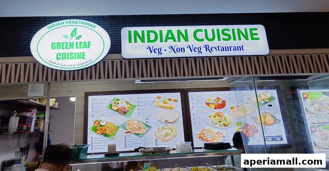 A food stall with signs for Indian Cuisine and Green Leaf Cuisine, displaying various dishes.