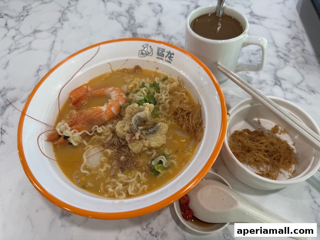 A bowl of prawn noodle soup with a side of crispy noodles and a cup of coffee.