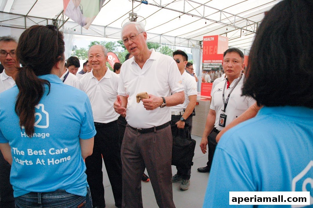 People in a gathering, with one person wearing a blue shirt with "Homage" and a slogan.