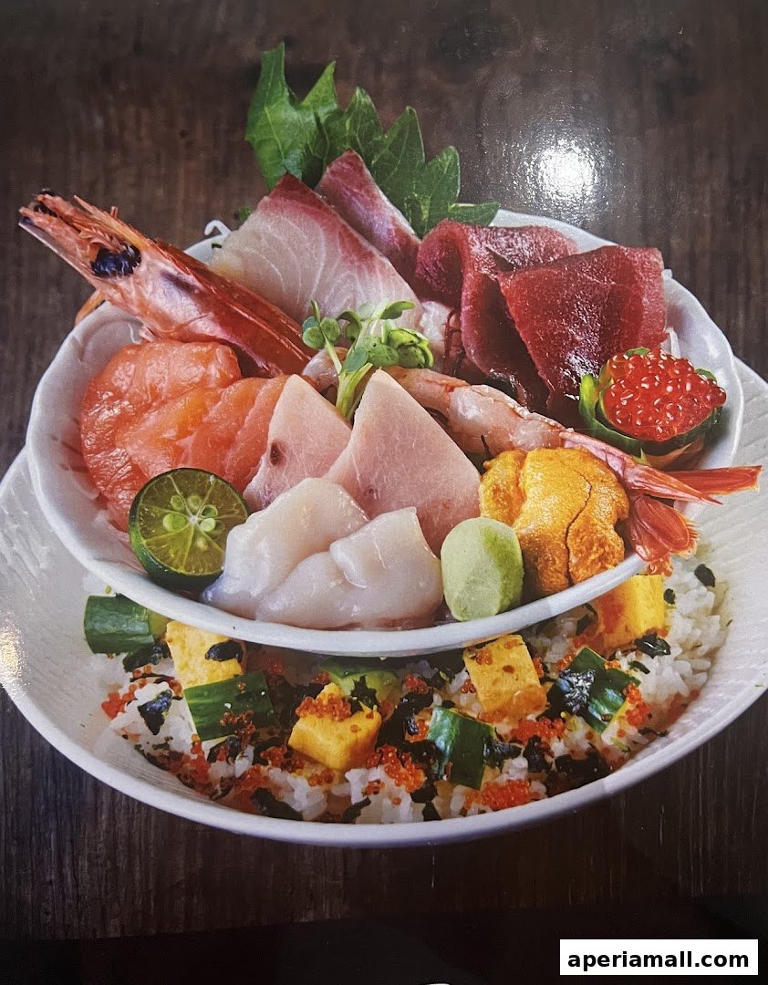 A vibrant bowl of chirashi sushi with assorted fresh sashimi and toppings over rice.