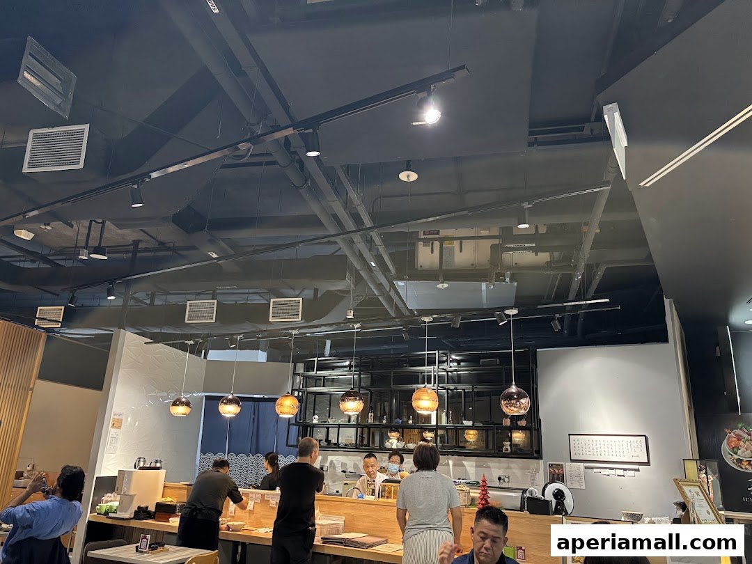 Interior view of a Japanese restaurant with diners and staff at the counter.