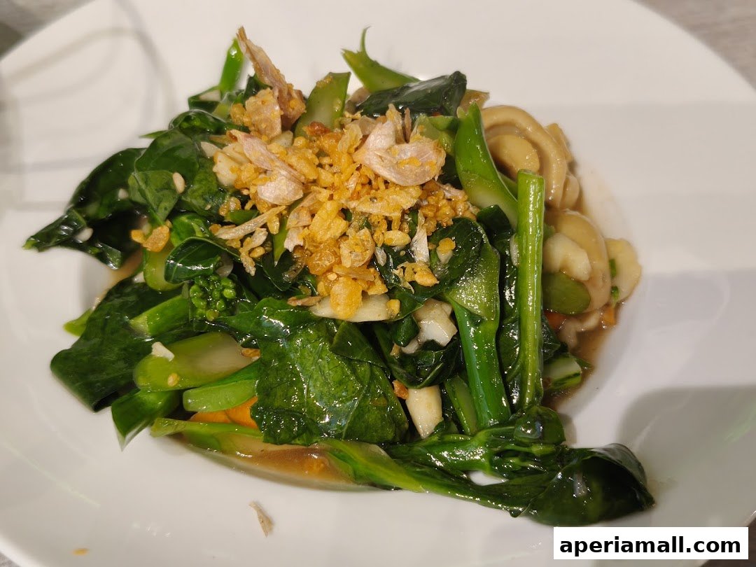 A plate of stir-fried Chinese broccoli with garlic and crispy fried shallots.