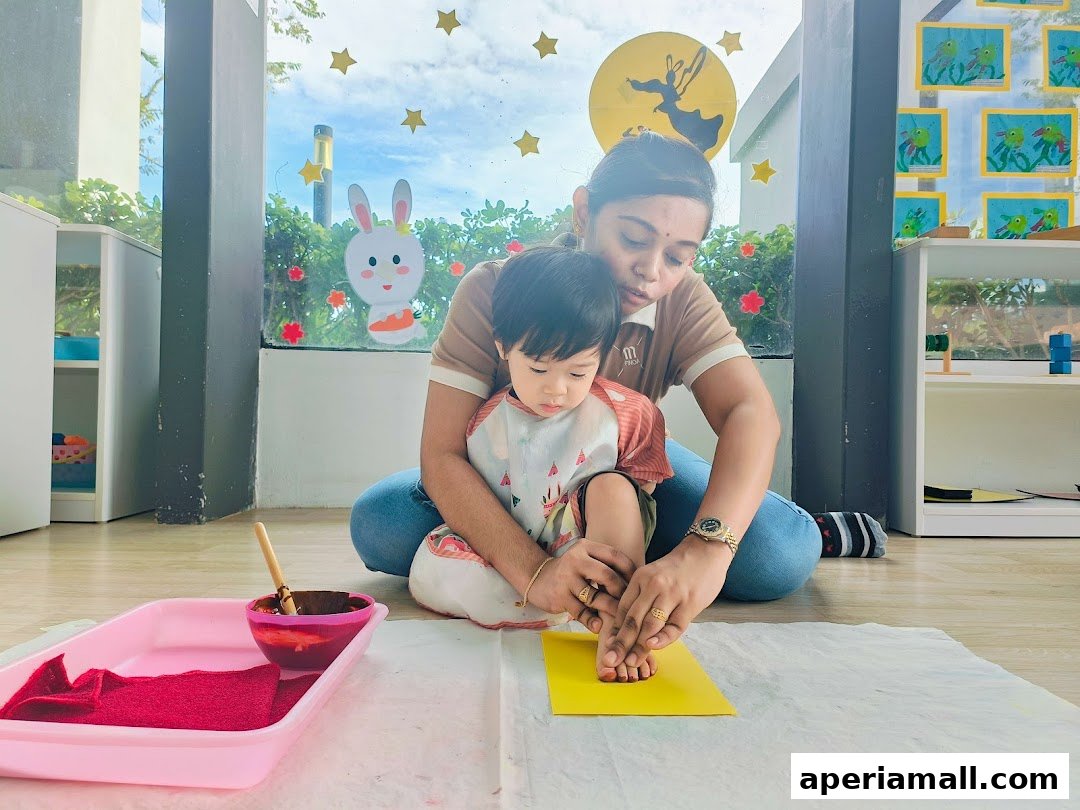 A teacher helps a child with a craft activity, likely involving paint or ink.
