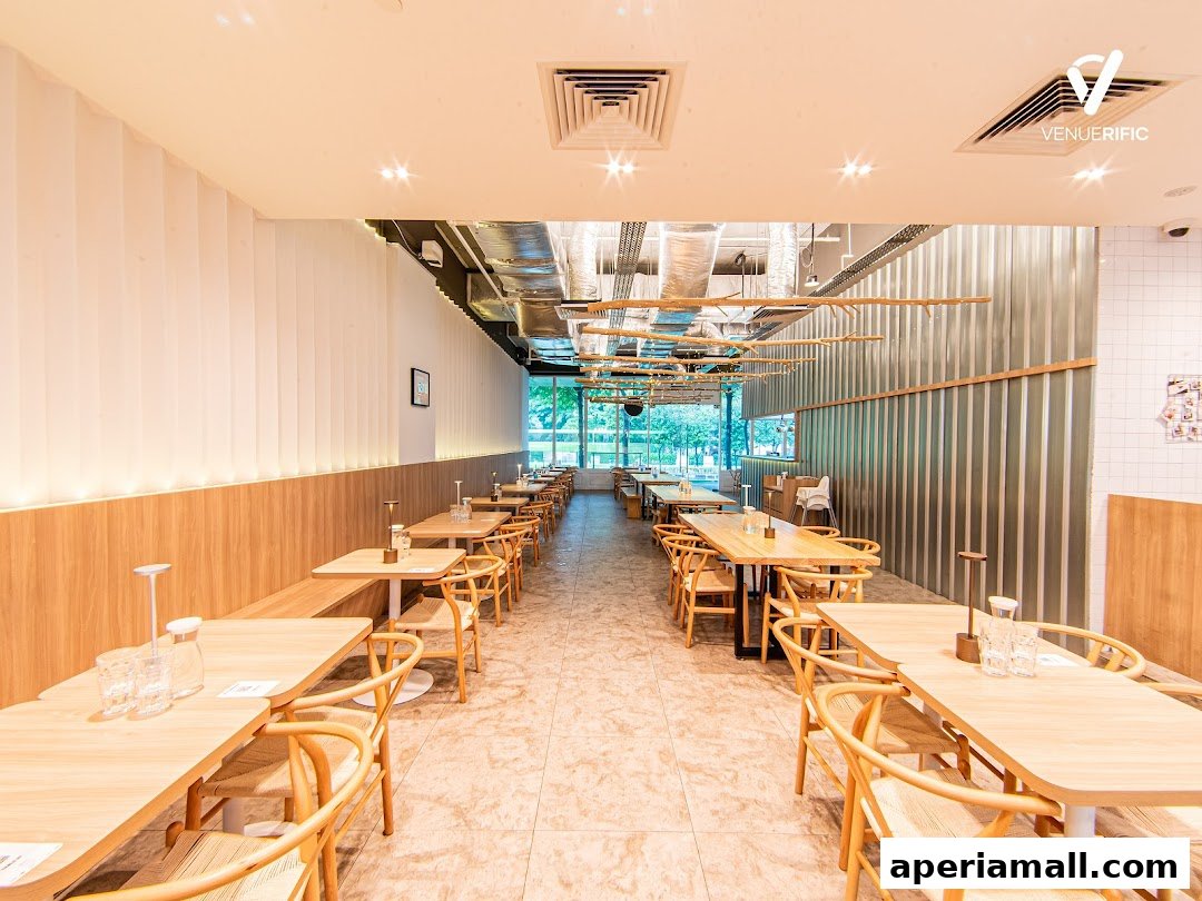 Interior view of a modern restaurant with wooden tables and chairs, and natural light.