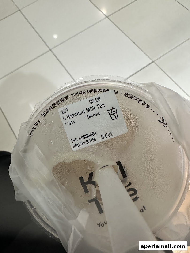 A close-up of a KOI Thé bubble tea cup with a straw and condensation.