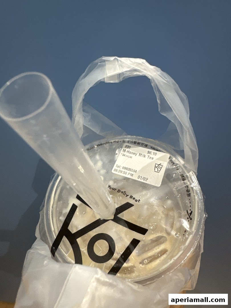 A KOI Thé M-Honey Milk Tea with konjac in a plastic bag.