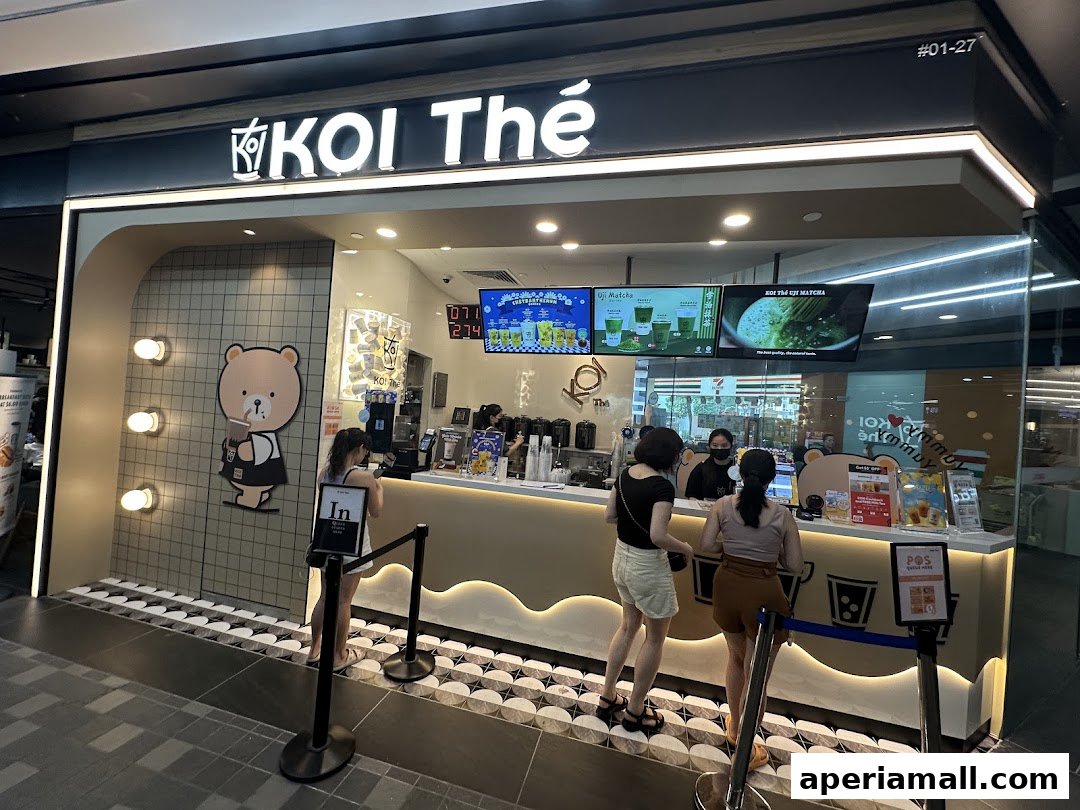 A KOI Thé bubble tea shop with customers ordering at the counter.