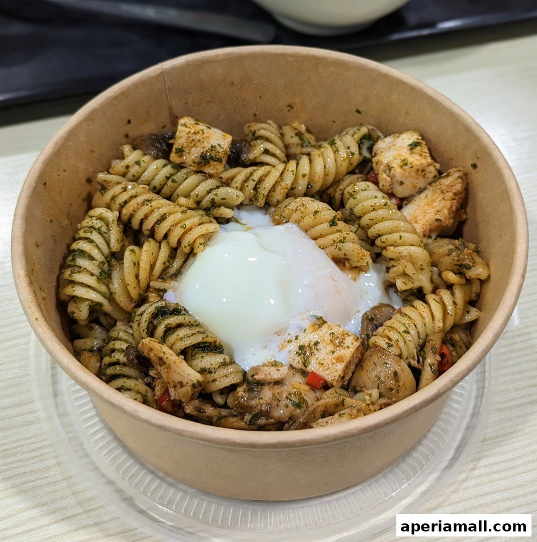 A bowl of fusilli pasta with chicken, mushrooms, and a poached egg.