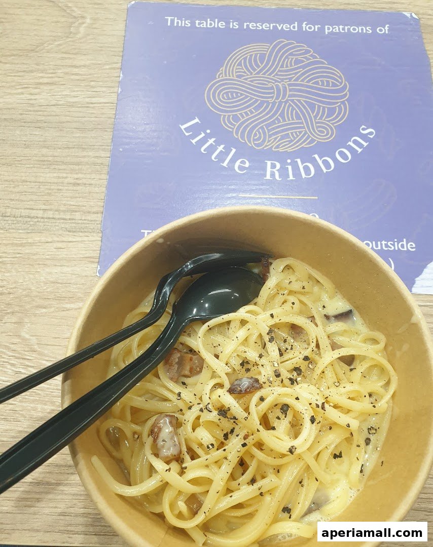 A bowl of pasta with sauce and black pepper, with a reservation sign in the background.