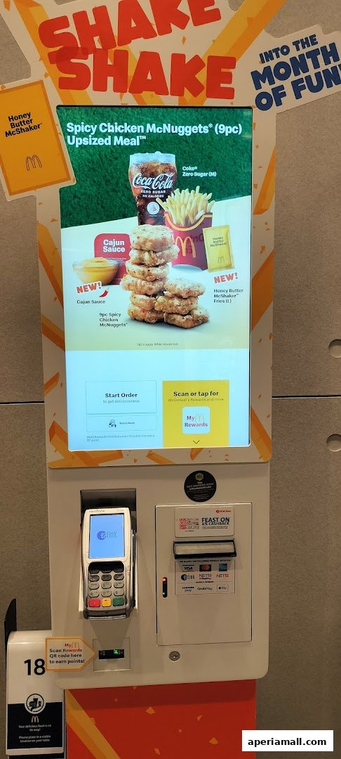 A McDonald's self-order kiosk displaying a Spicy Chicken McNuggets Upsized Meal and Honey Butter McShaker Fries.