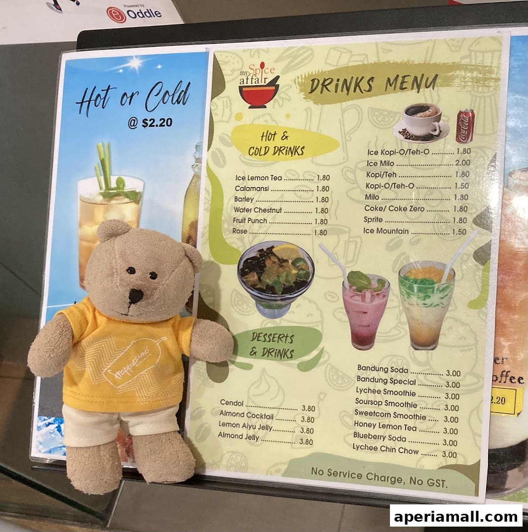 A teddy bear in a yellow shirt stands next to a menu for My Spice Affair drinks and desserts.