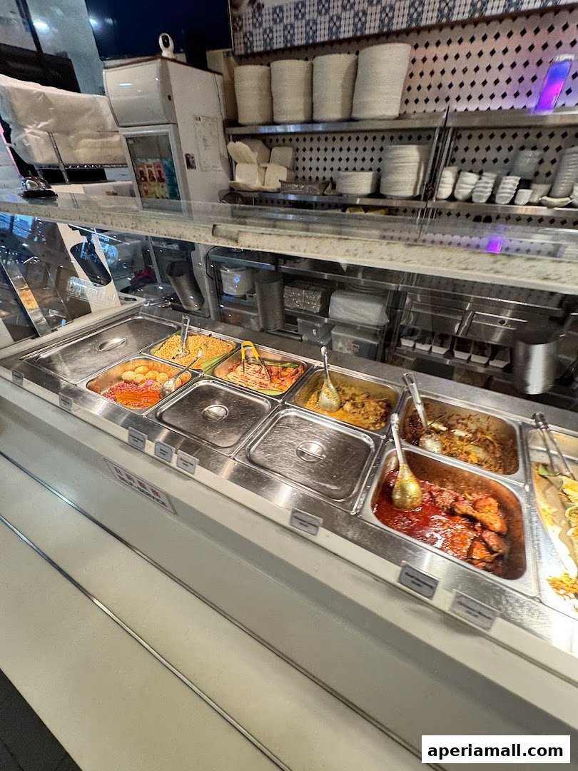 A display of various food dishes in metal trays at a self-service counter.