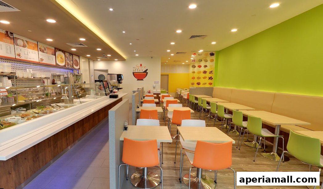 Interior of a brightly lit restaurant with a food display counter and seating area.
