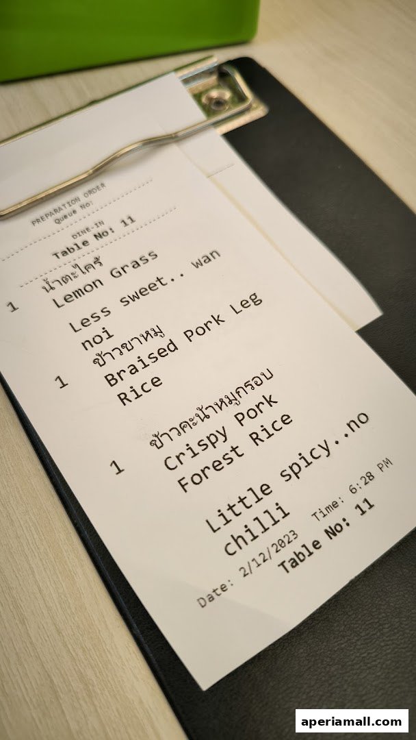 A close-up of a Thai food order slip with various dishes listed.