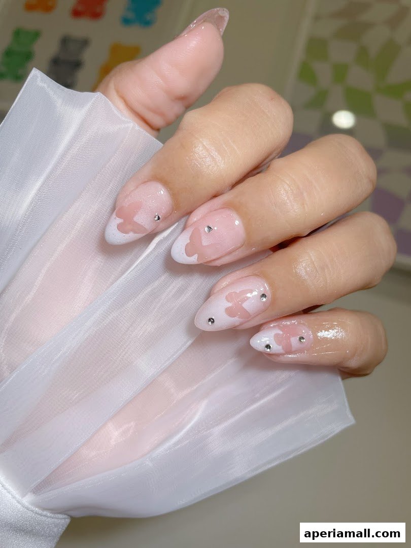 Close-up of a hand with elegant French tip nails adorned with pink butterfly designs and small rhinestones.