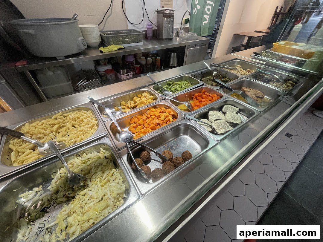A display of various healthy food options, including pasta, vegetables, and meatballs.