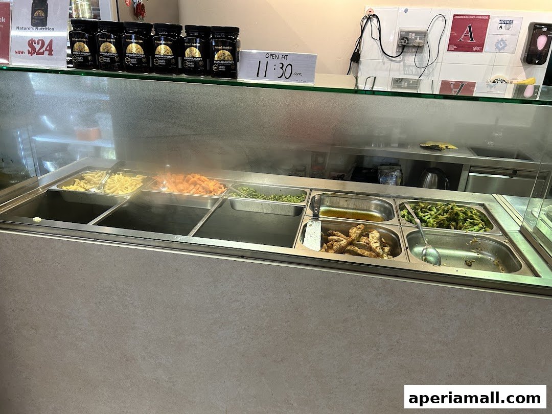 A display counter with various healthy food options like pasta, vegetables, and chicken.
