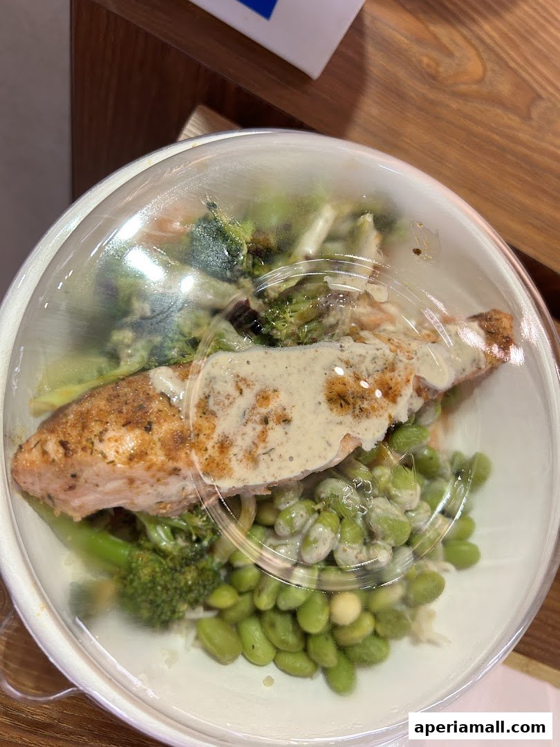 A close-up of a healthy salad bowl with salmon, broccoli, and edamame.