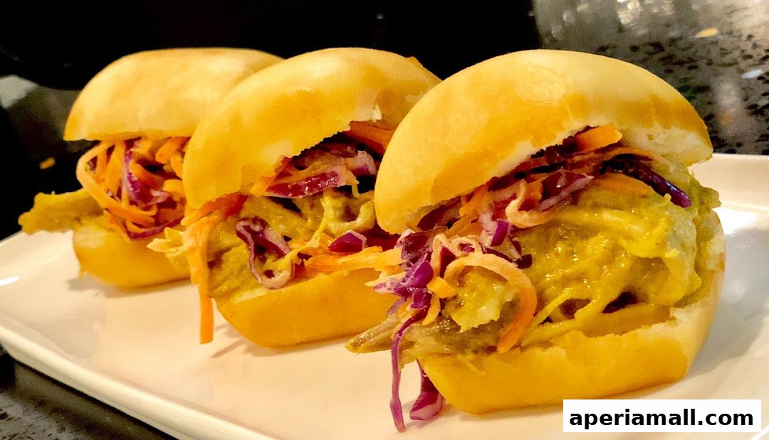 Three mini sandwiches with shredded carrots, red cabbage, and a creamy sauce on a white plate.