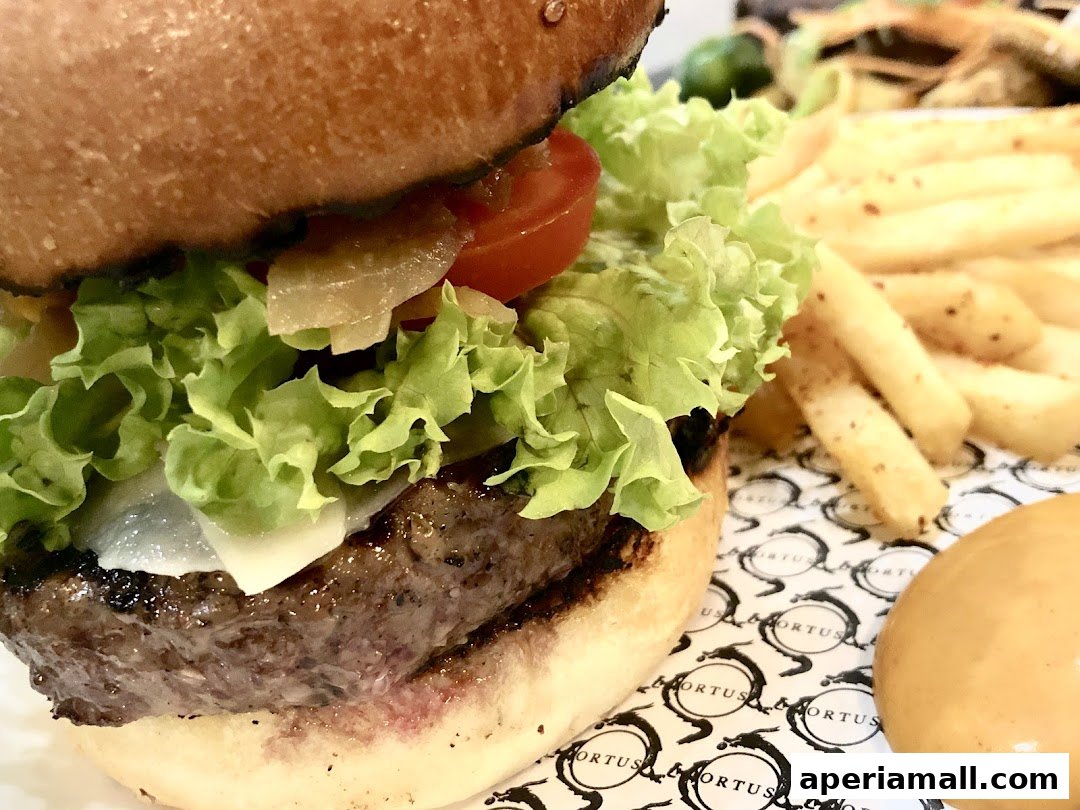 A close-up of a gourmet burger with fresh lettuce, tomato, cheese, and a side of fries.