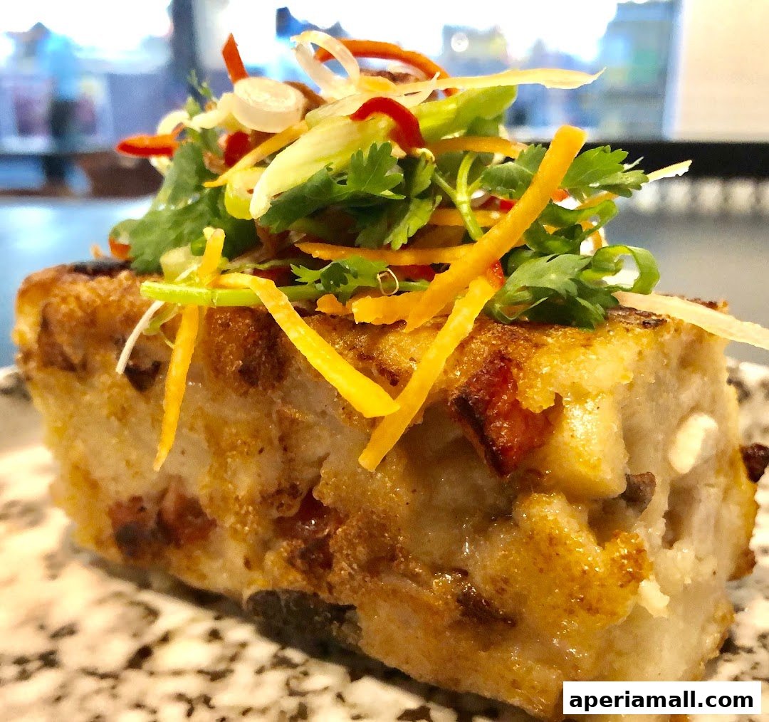 A close-up of a savory pastry topped with fresh herbs and julienned vegetables.
